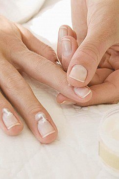 Massaging cuticle cream into mature nails at night