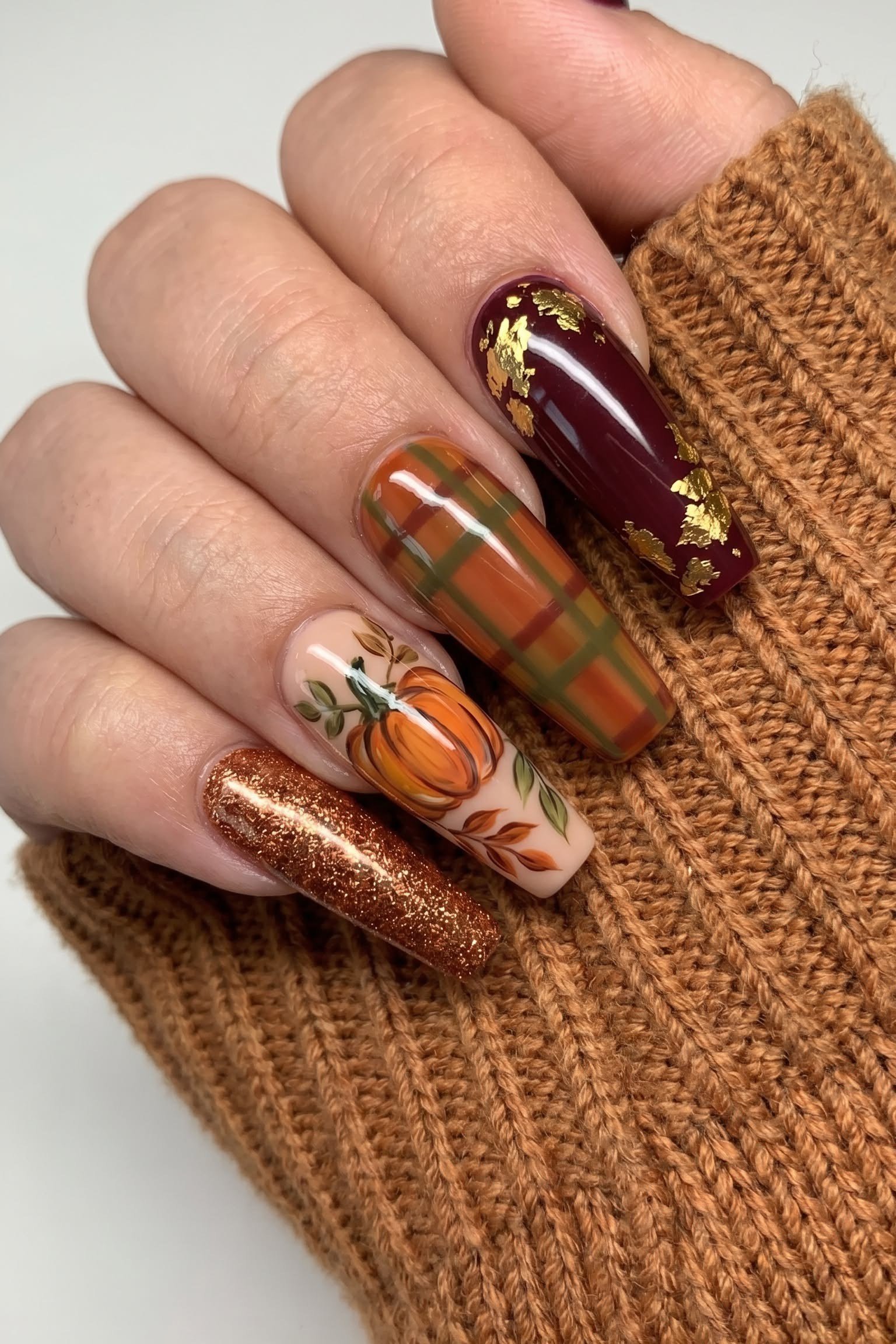 Burgundy nails with plaid and pumpkin nail art, fall nail design for older women