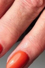 Fiery orange red gel nails for mature hands