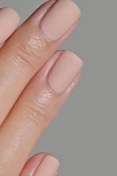 Soft pink nude nails on grey background