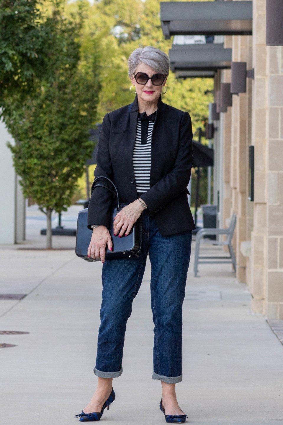 Black blazer over striped top with cropped dark jeans for women over 60