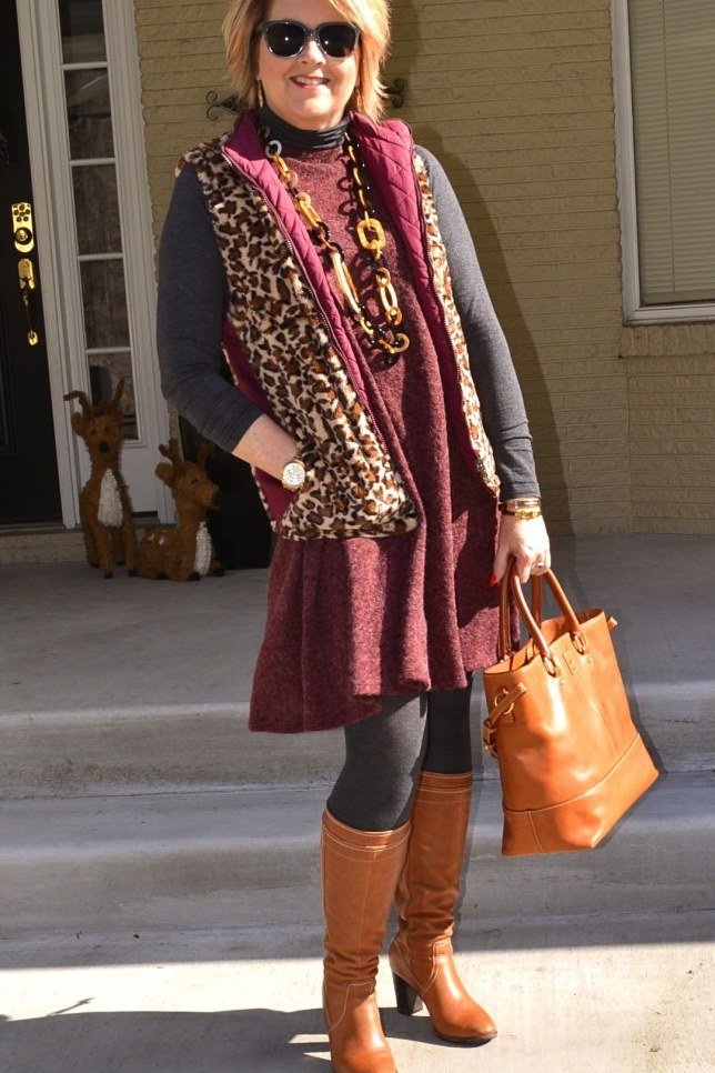 Fall city outfit for women over 50: burgundy dress leopard scarf cognac knee boots orange bag
