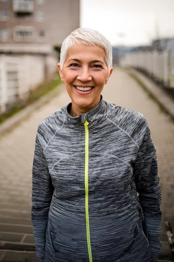 Silver wispy pixie haircut with soft layers and sporty jacket for older women