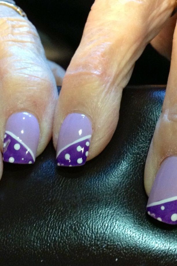 Purple french tip nails with white polka dot accents