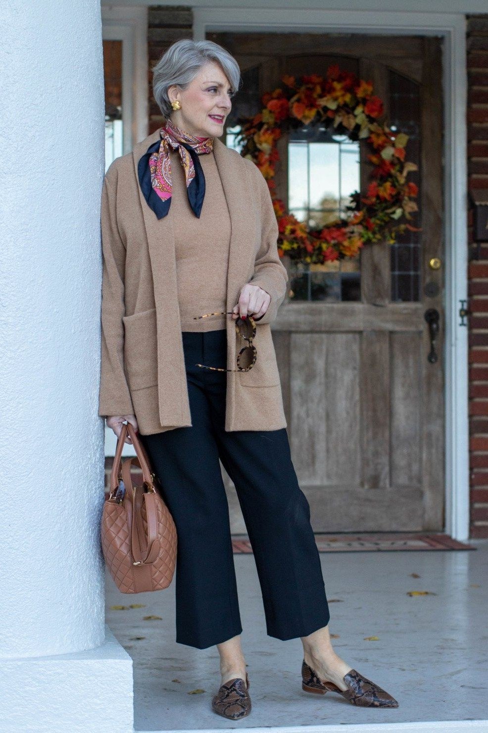 Elegant fall outfit for women over 70: camel cardigan with printed scarf