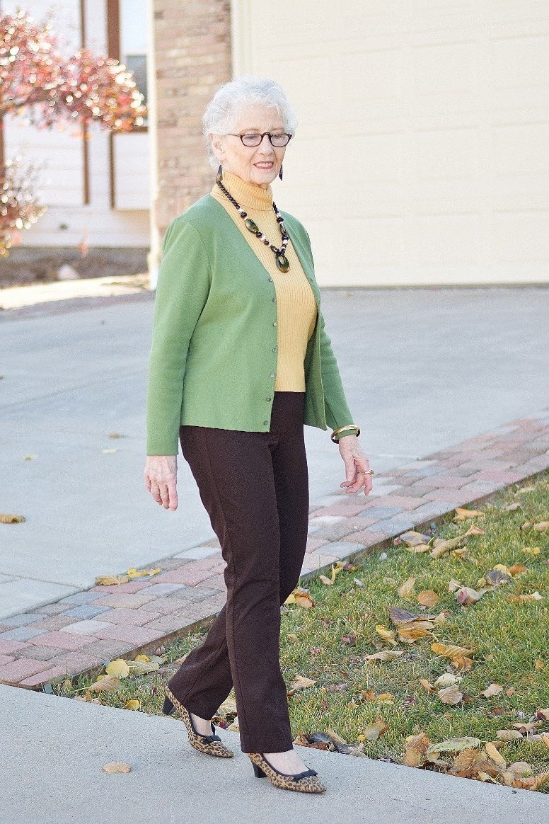 Lime green cardigan over mustard yellow top with brown straight trousers