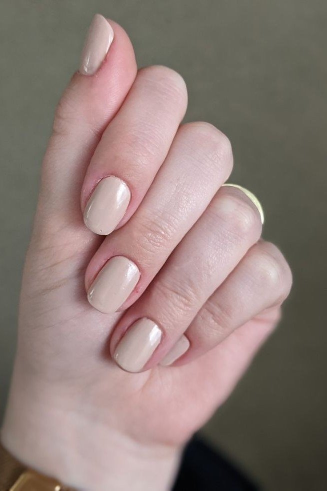 Milky nude almond nails in fist pose