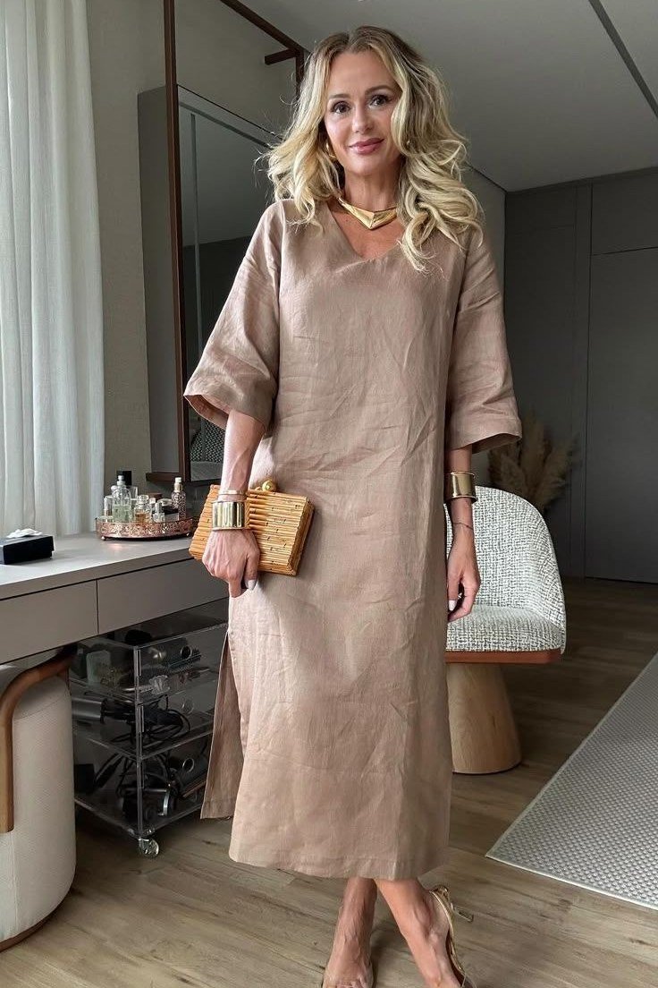 Taupe dolman-sleeve midi dress with clutch, older blonde woman, interior