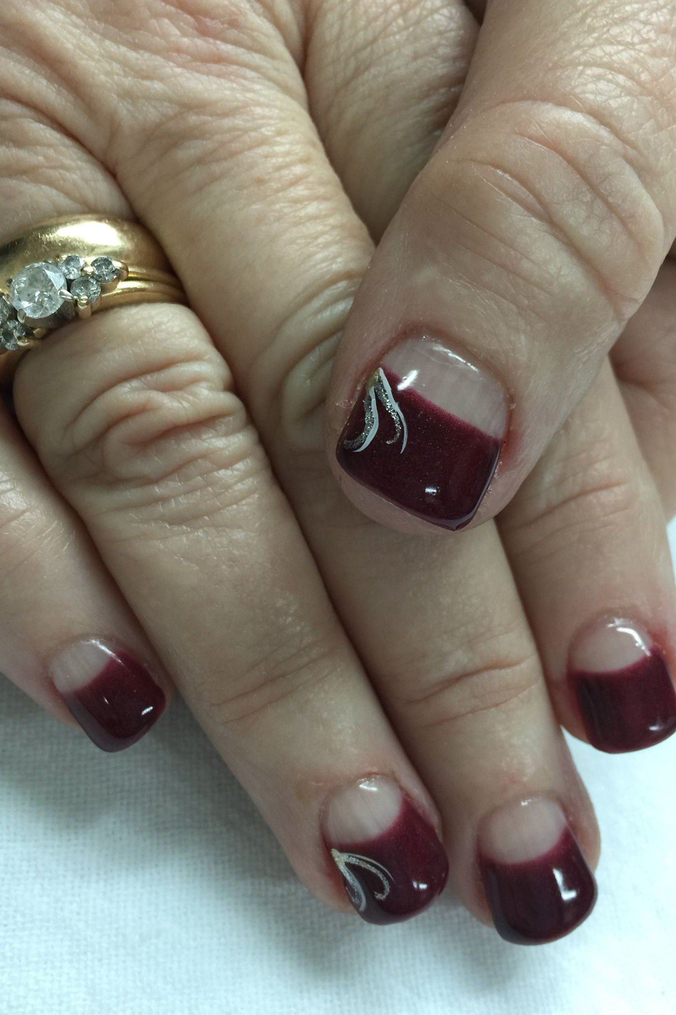 Burgundy nails with black swirl art for older women