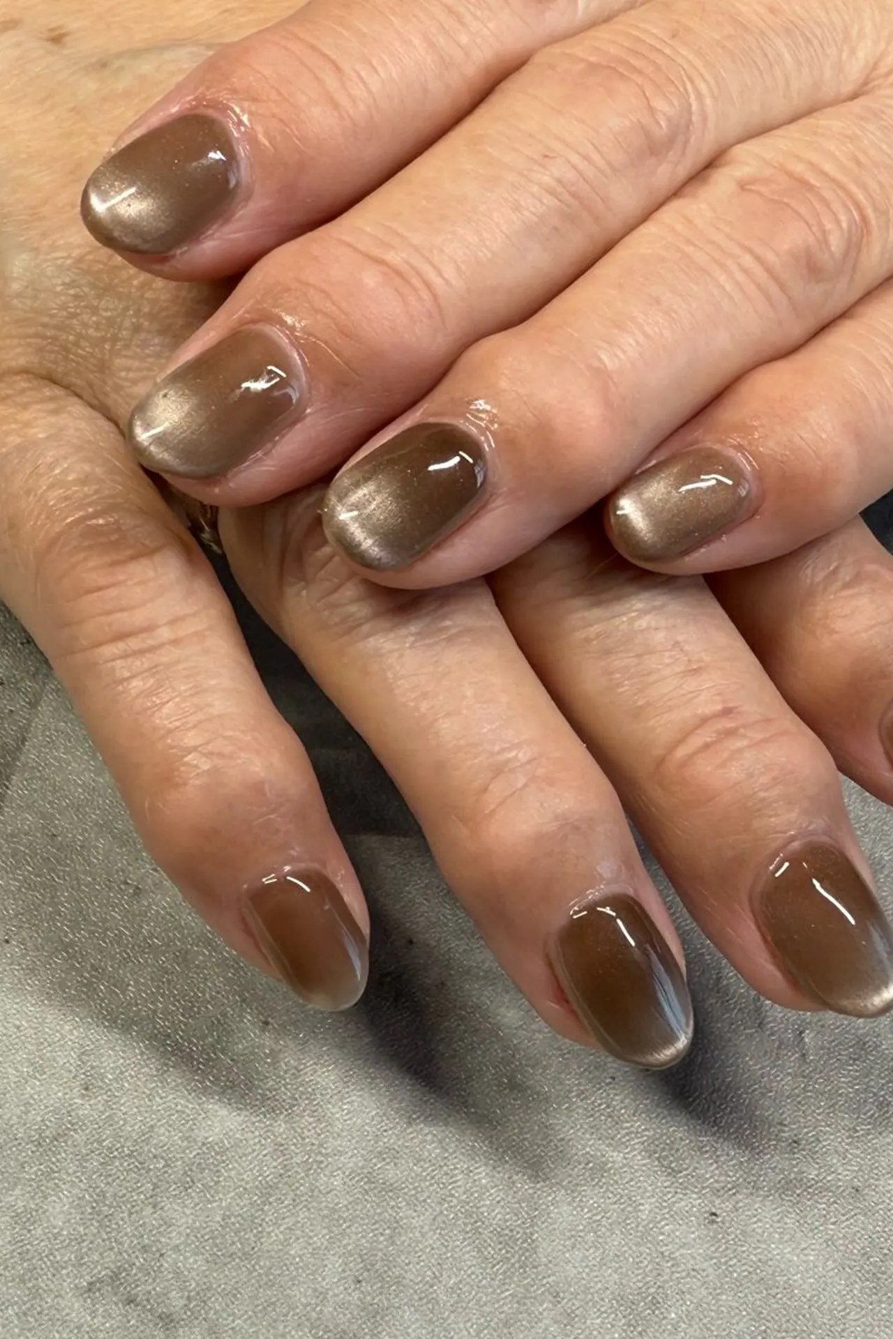Olive Bronze Cat Eye Nails - Warm olive bronze with golden magnetic shimmer covers these short, rounded nails.