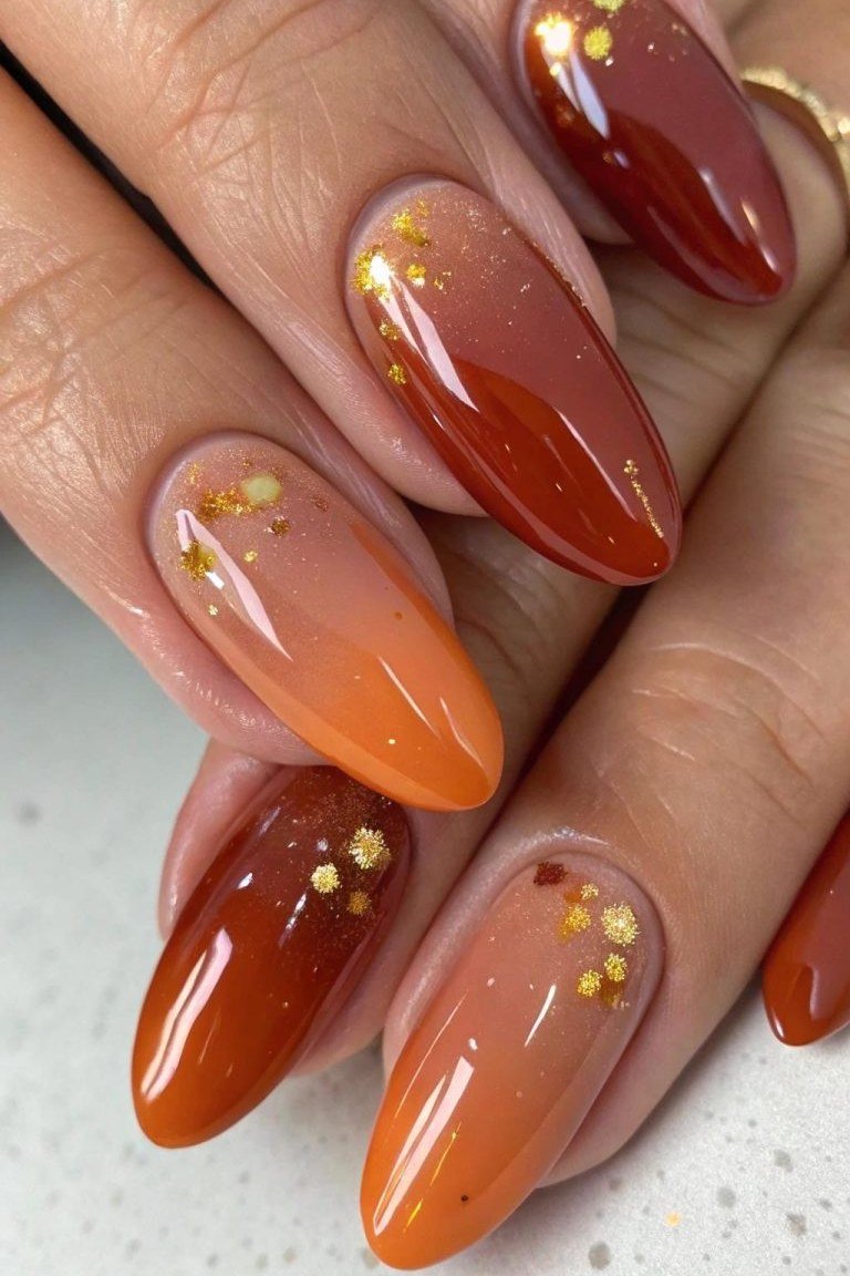 Amber Ombre Coffin Nails with Gold Flakes - Warm amber fades across these medium coffin nails, dotted with tiny gold flakes near the tips.