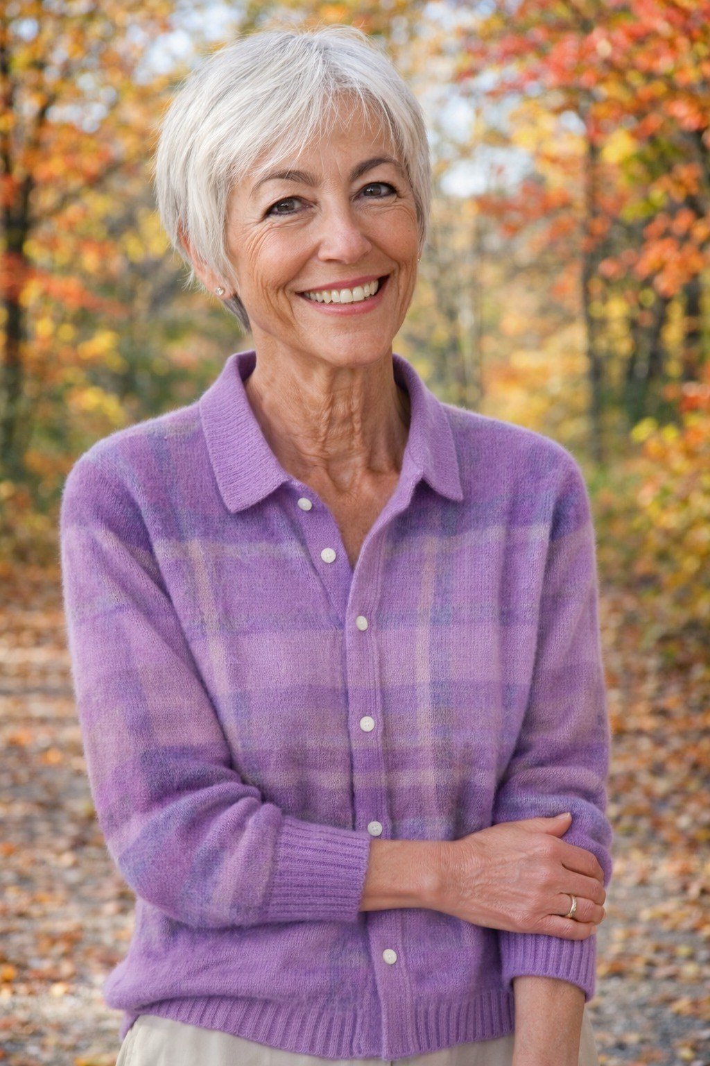 older woman in purple plaid flannel shirt with jeans, autumn trees