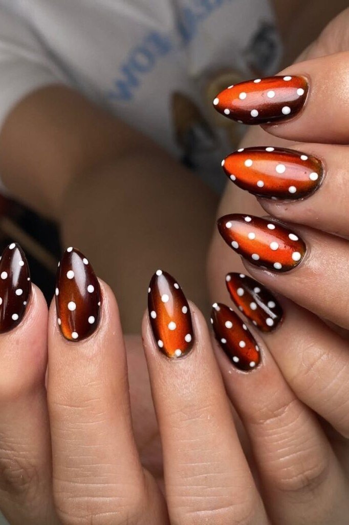 Almond nails with burnt orange base and white fawn spots fall design