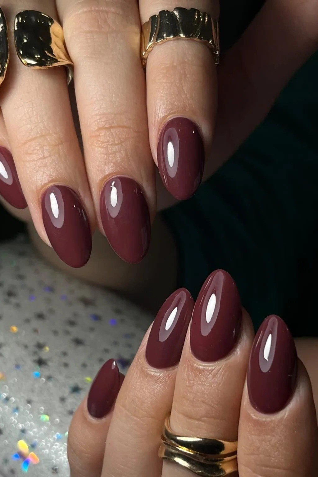Mauve burgundy almond gel nails with stacked rings, muted fall manicure