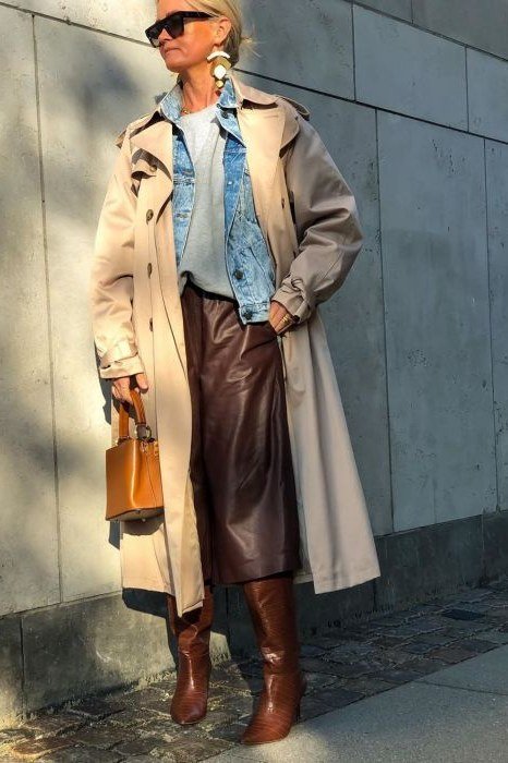 Beige trench coat with denim shirt and brown leather skirt, trendy fall outfit for women over 40