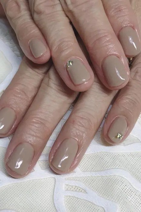 Taupe nude glossy crystal accents older hands nails for women over 50