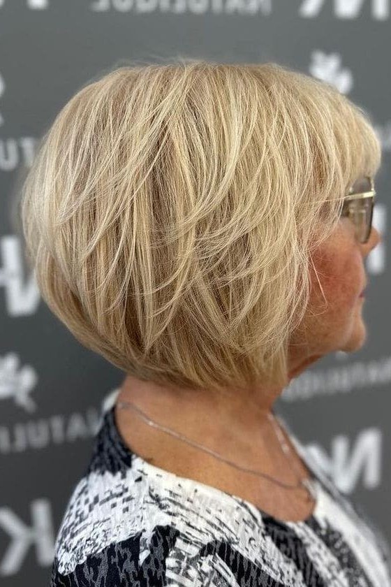 blonde layered bob, side view, salon — chin-length layered bob hairstyle for women over 50