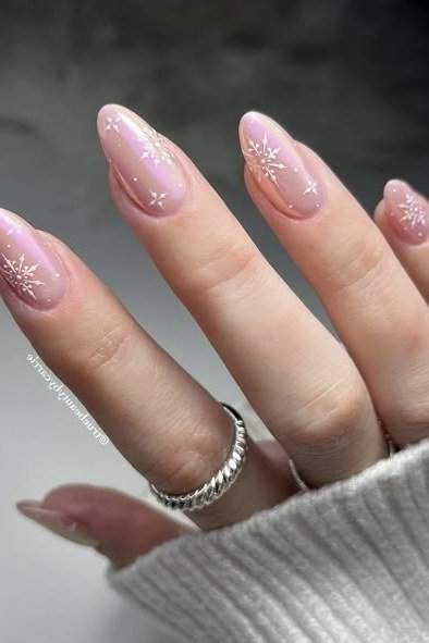 Pale pink nails with delicate snowflake art - classy Christmas nail idea for women over 70