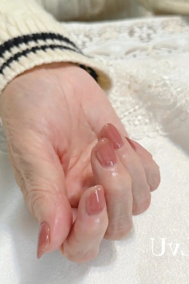 Warm terracotta solid polish on older hand - classy nail design for older women