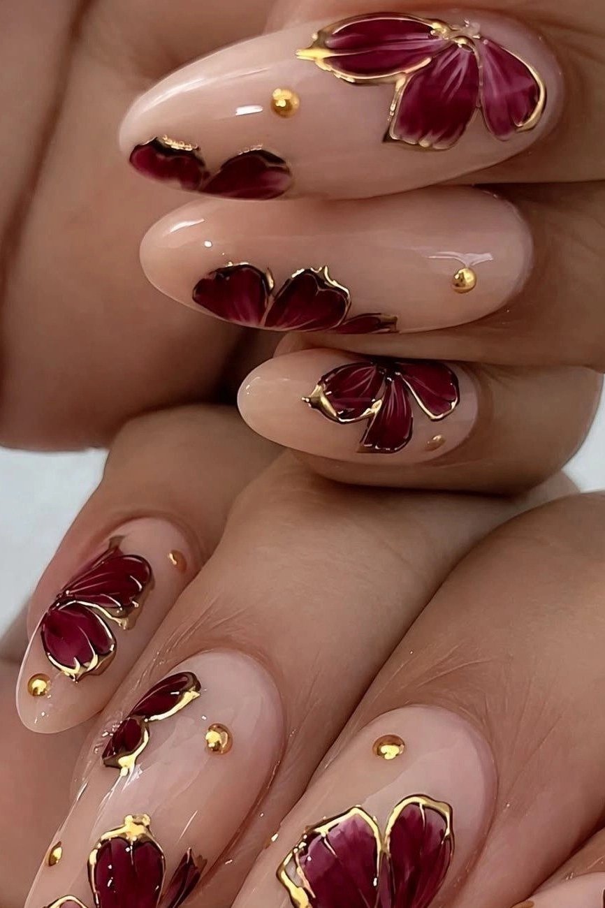 Nude nails with burgundy and gold floral art for women over 50