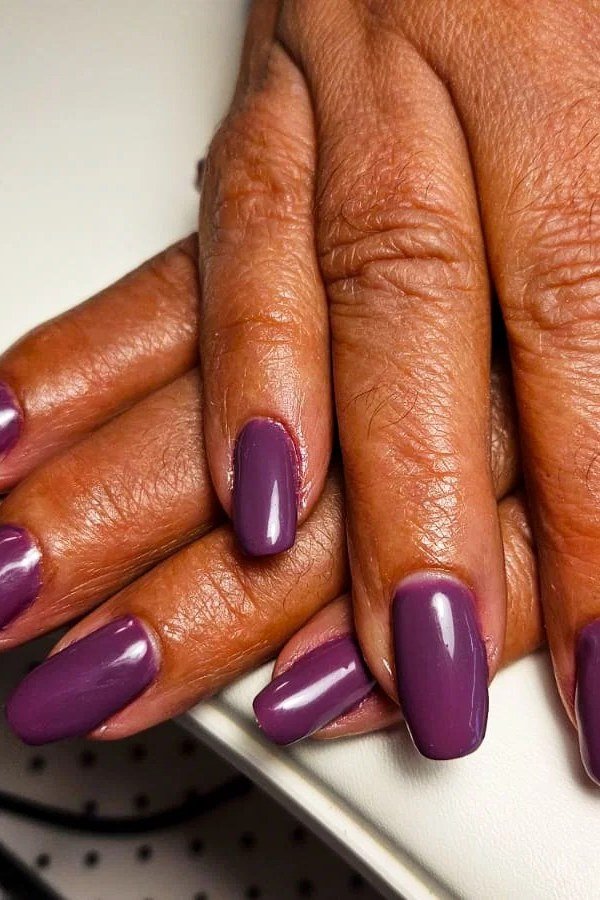 Deep Plum Oval Nails on Mature Hands - old money fall nail color for women over 40