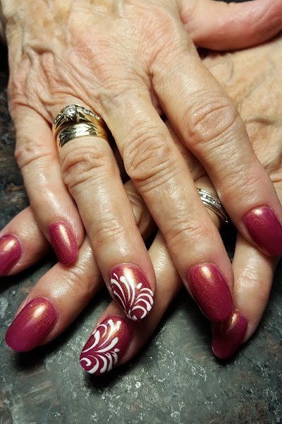 Red nails with glitter swirl art for older women
