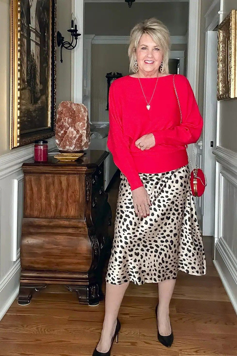 Blonde woman in red sweater with leopard-print midi skirt and black heels