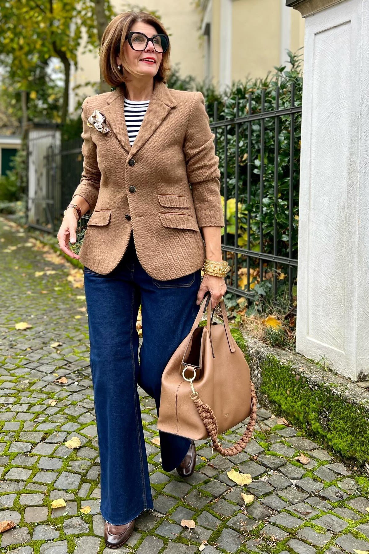Brown blazer with striped top and wide dark jeans, casual fall outfit for women over 50
