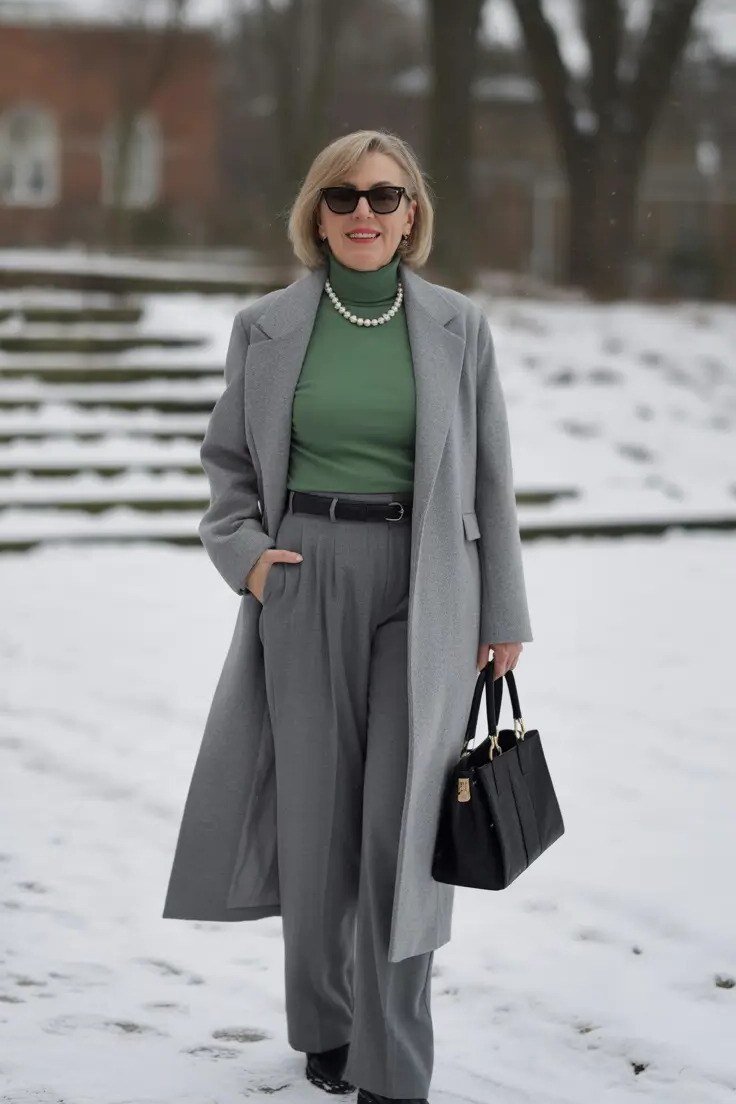 Gray midi coat over a green turtleneck and gray trousers for women over 50 at work