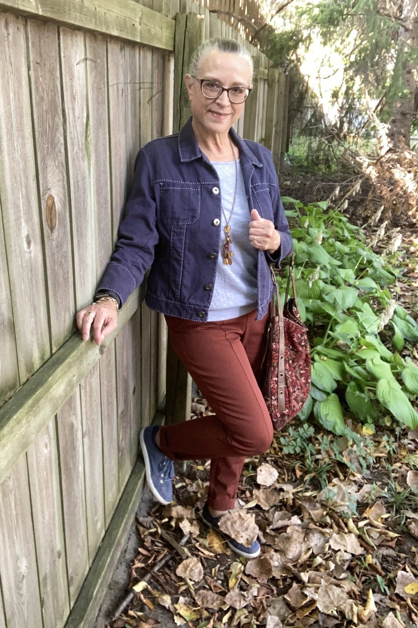 Navy quilted jacket with rust trousers fall outfit idea for women over 60