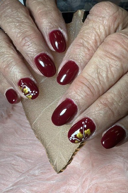 Deep Red with Gold Foil Art - fall nail color idea for women over 60