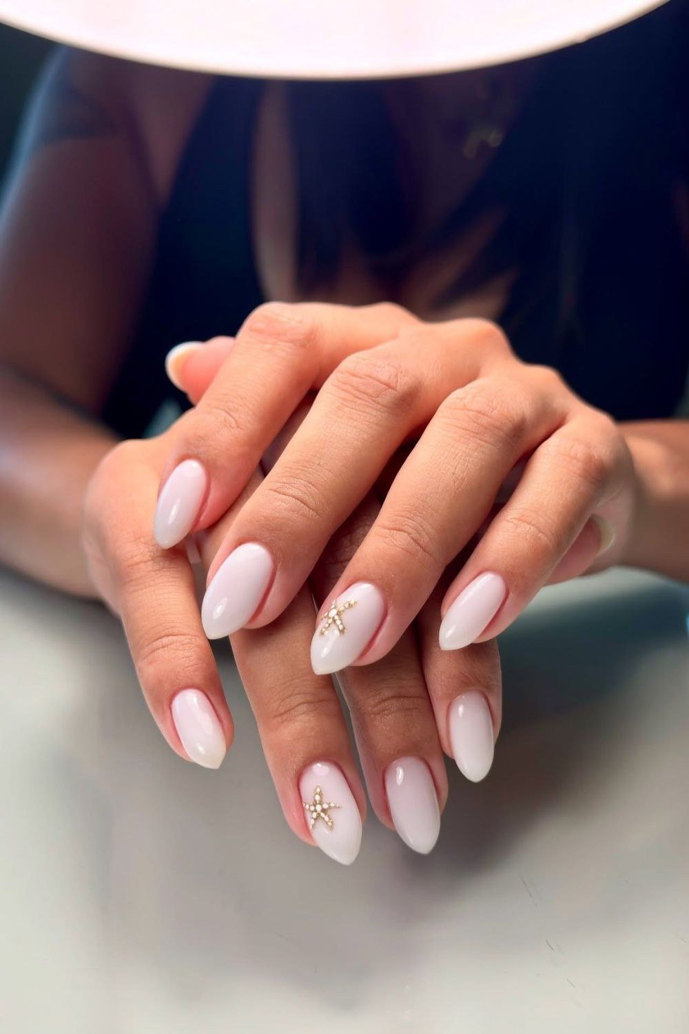Milky white nails with tiny gold star accents