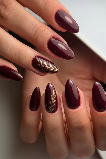 Burgundy nails with gold leaf art for older women
