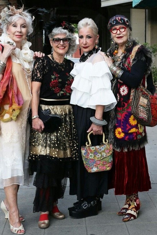 Five stylish older women in mixed bold outfits posing on a city street - summer dress for women over 50
