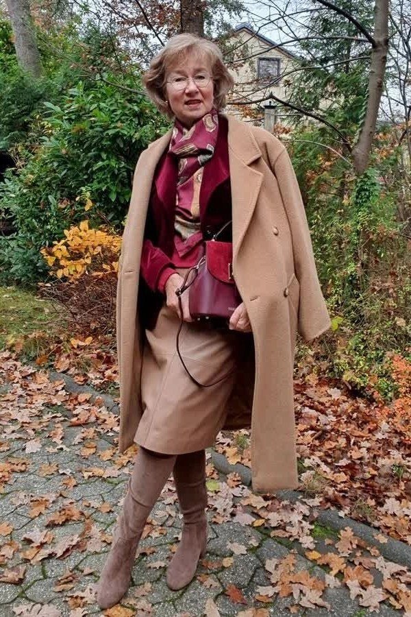 Fall city outfit for women over 50: camel coat burgundy scarf camel skirt taupe boots