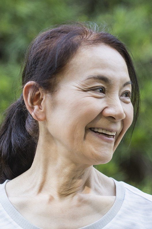 Long dark hair in low ponytail for women over 50