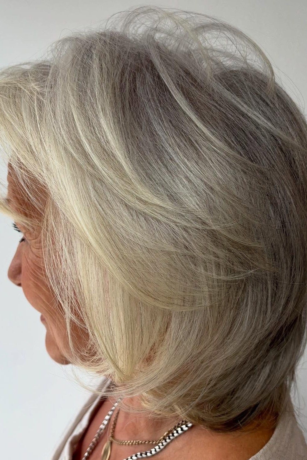 Silver-blonde layered bob shown in side profile for women over 60