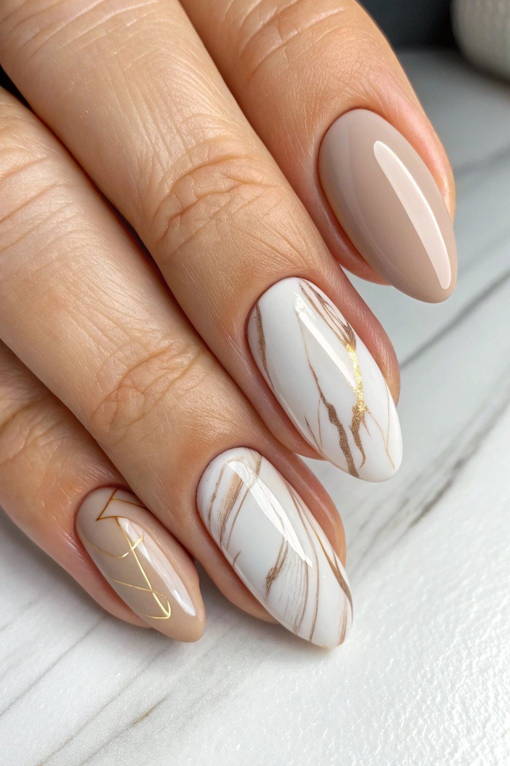 taupe almond nails with white and gold marble art