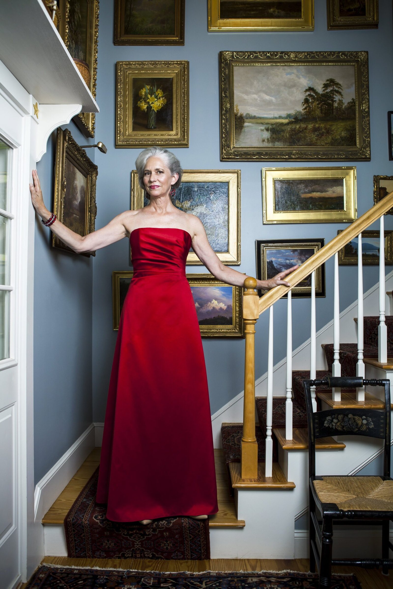 Red strapless gown on staircase for women over 50, fall date night outfit
