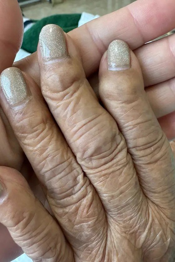 Mature hands with subtle shimmer glitter nail polish