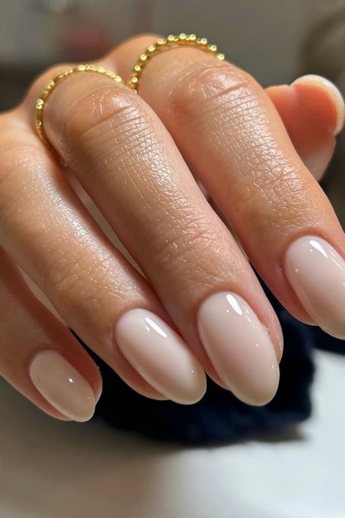 Nude almond nails with gold ring for women over 50