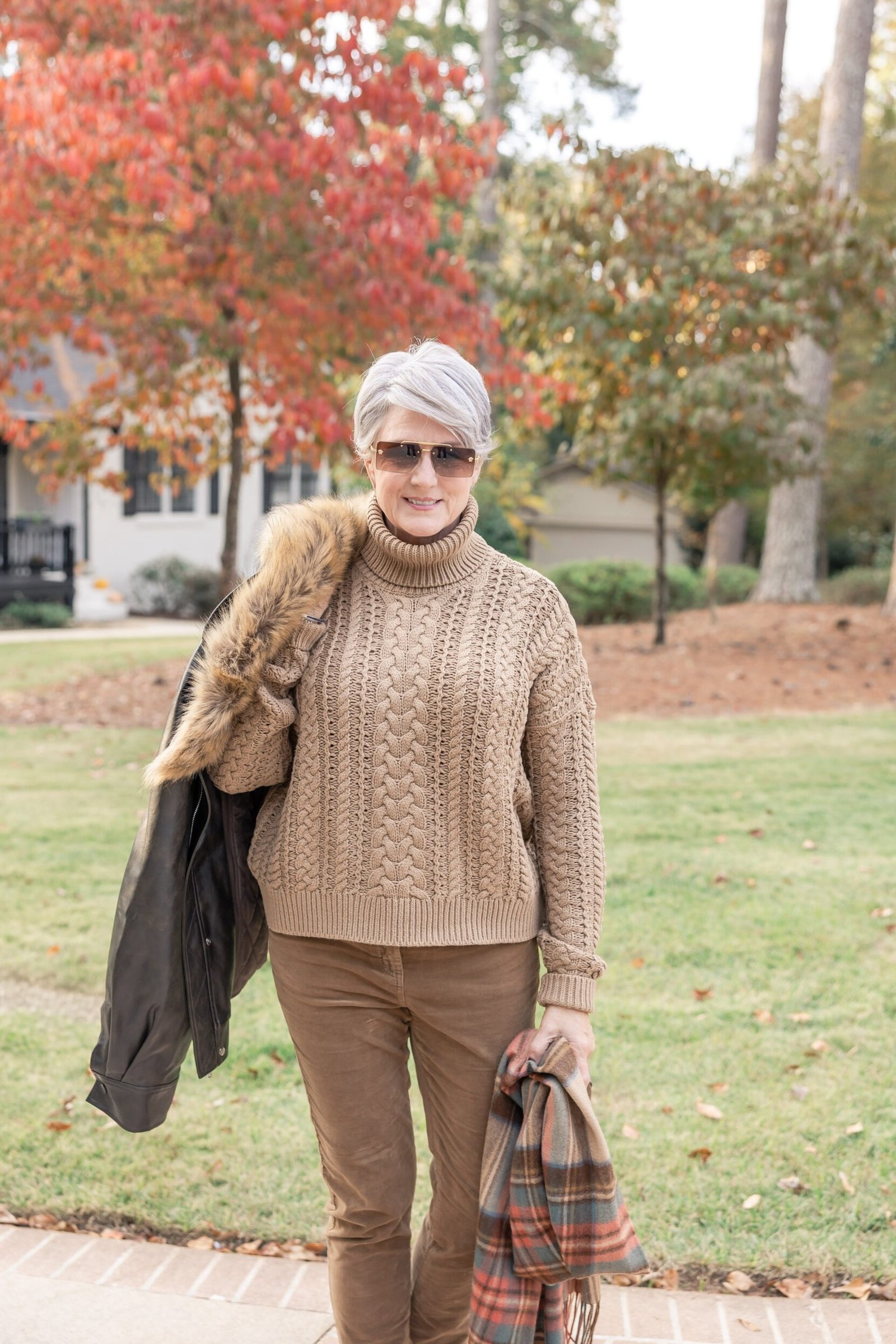 Casual fall outfit for women over 60: grey turtleneck, black wide leg trousers, black ankle boots