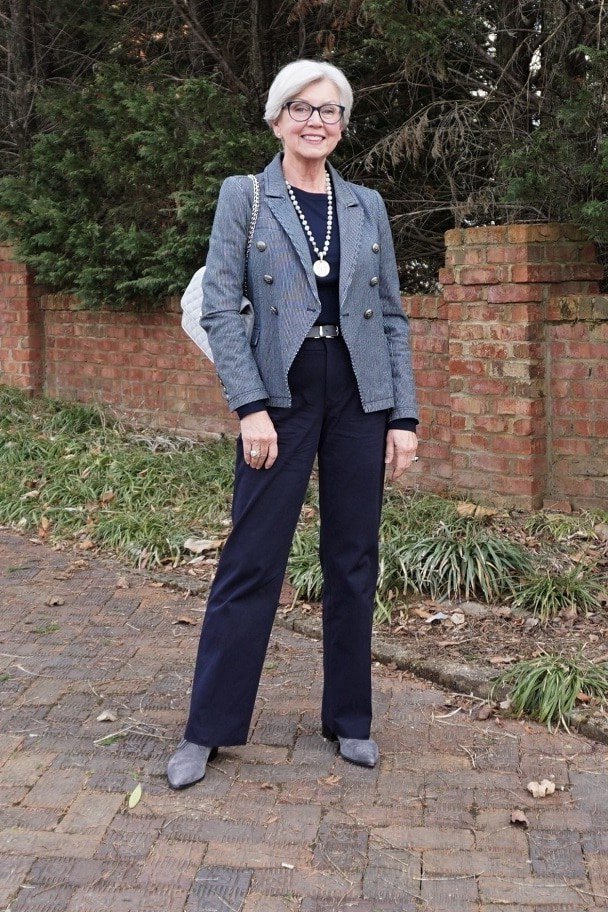 Woman over 50 in a gray blazer with navy trousers outdoors
