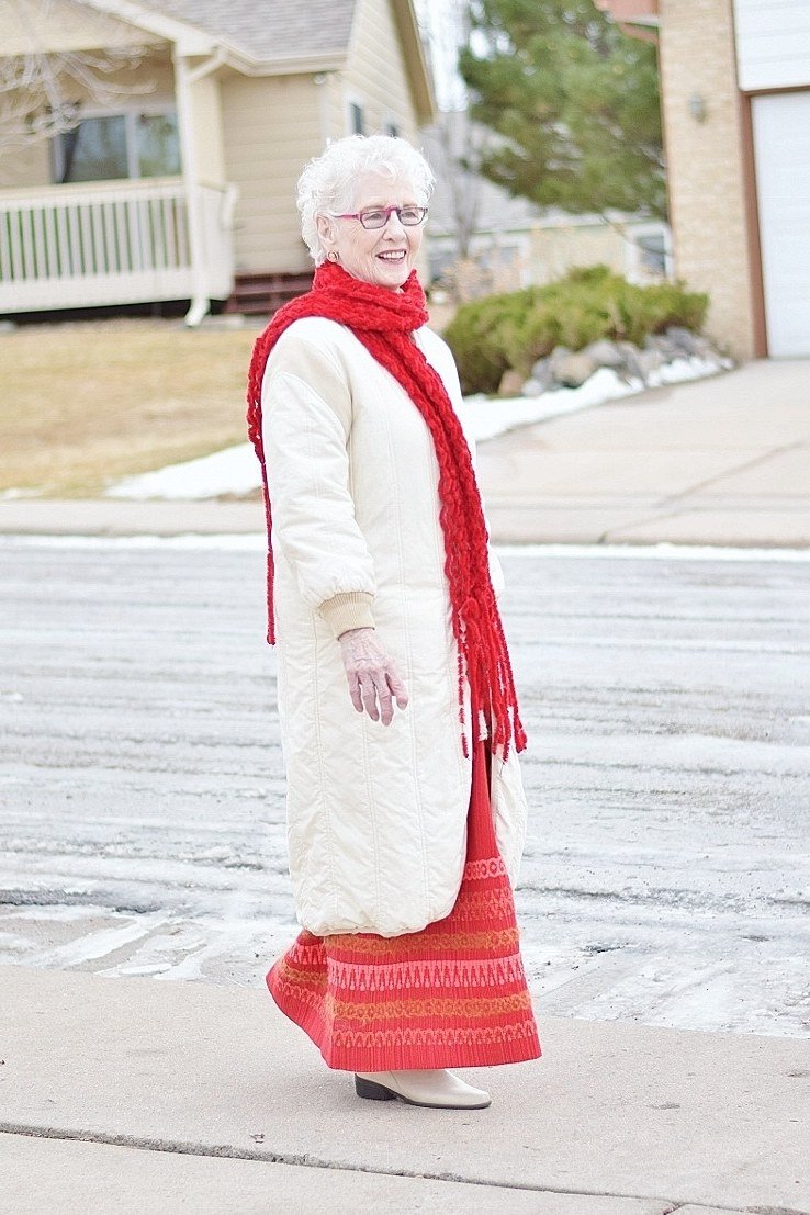 cream knit coat with red scarf and red pleated midi skirt church outfit for women over 60