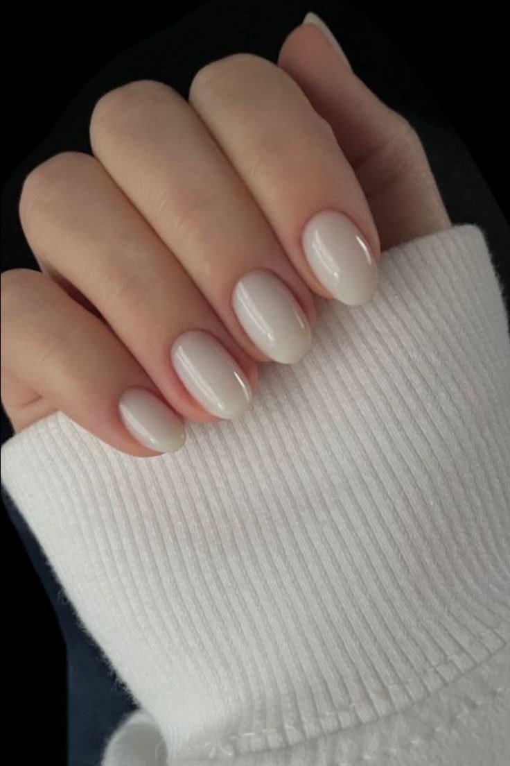 Short milky white nails with a white knit sweater cuff