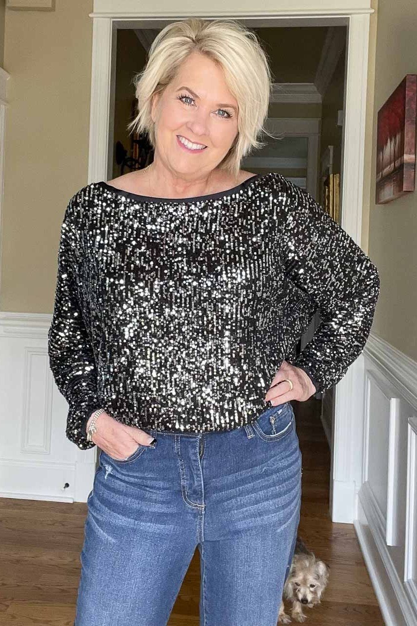 holiday evening outfit for women over 60: silver sequin top with blue jeans