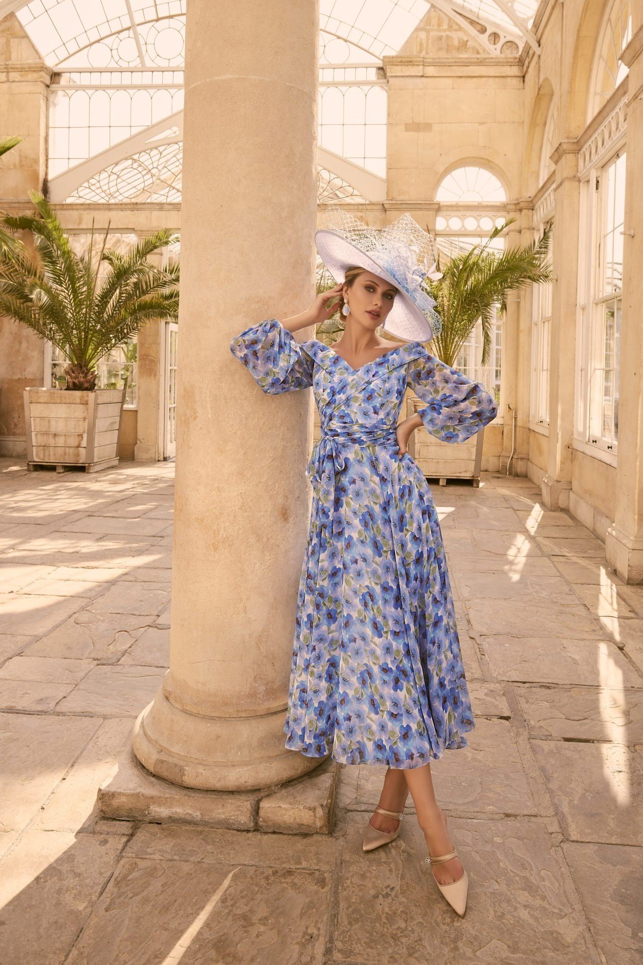 Blue floral midi dress with white hat, courtyard - wedding guest outfit for women over 50
