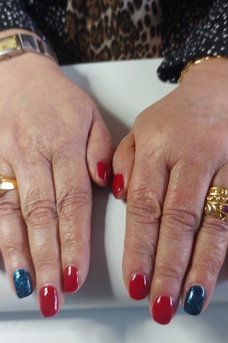 Red nails with blue glitter accent nails
