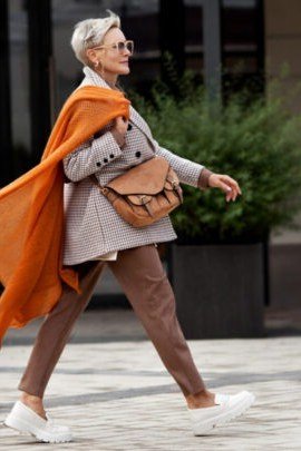 Rust colored shawl with brown trousers fall outfit idea for women over 60