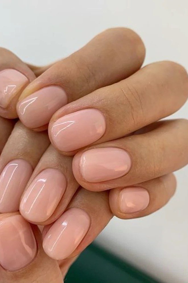 Sheer nude pink nails clasped hands